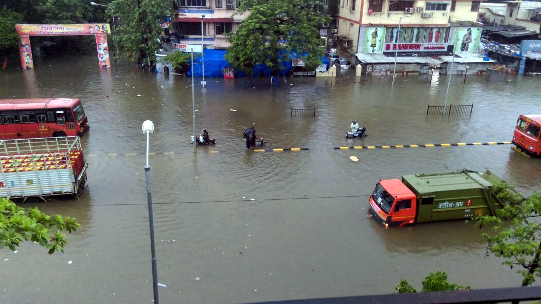 Vehicles ply on a submerged road as heavy rain hit train services in Mumbai on June 19, 2015 Mumbai Rain