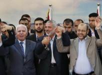 Senior Fatah official Azzam Al-Ahmed (L), head of the Hamas government Ismail Haniyeh (C) and senior Hamas leader Moussa Abu Marzouq hold their hands after announcing a reconciliation agreement in Gaza City April 23, 2014.