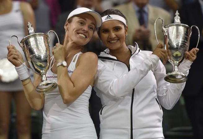 Sania Mirza and Martina Hingis pose with the Wimbledon title after winning the dramatic final. Sania Mirza and Martina Hingis