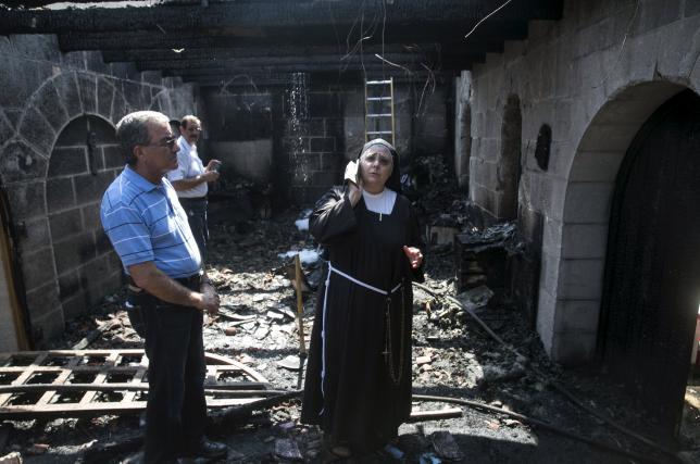 A nun stands at the scene of a fire in the Church of Loaves and Fishes on the shores of the Sea of Galilee in northern Israel June 18, 2015.