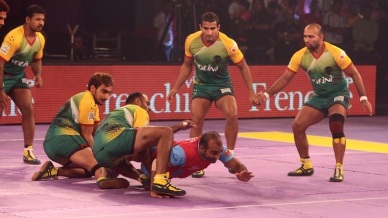 Patna Pirates (yellow/green) try to stop a Jaipur Pink Panthers man from conducting a raid in their match telugu titans