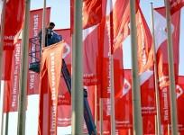 A worker installs advertising flags of British telecommunications company Vodafone outside an event