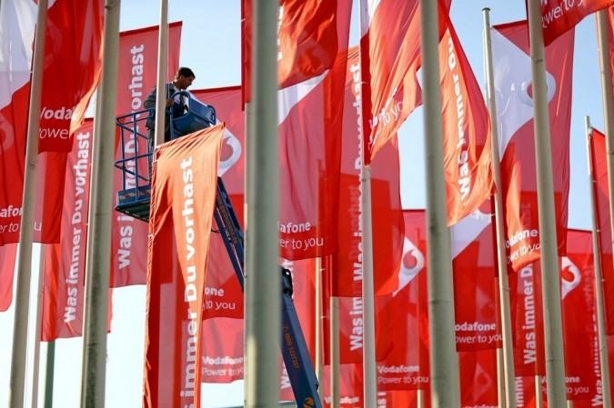 A worker installs advertising flags of British telecommunications company Vodafone outside the IFA event A worker installs advertising flags of British telecommunications company Vodafone outside the IFA event