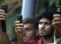 Kashmiri youth use their mobile phones to take pictures during the funeral of Feroz Ahmad Malik in Palhalan, north of Srinagar September 6, 2010