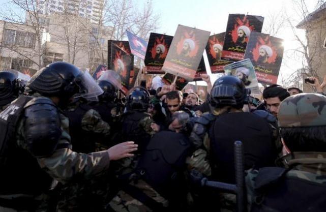 Protesters holding pictures of Shi'ite cleric Sheikh Nimr al-Nimr are pushed back by Iranian riot police during a demonstration against the execution of Nimr in Saudi Arabia, outside the Saudi Arabian Embassy in Tehran 3 January, 2016. Iran
