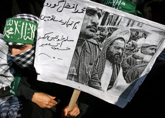 A man holding a poster of Afzal Guru afzal guru death anniversary, kashmir shutdown, hurriyat
