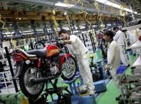 Employees work on an assembly line of Hero Motocorp during a media tour to the newly opened plant in Neemrana, in the desert Indian state of Rajasthan, Oct.20, 2014.