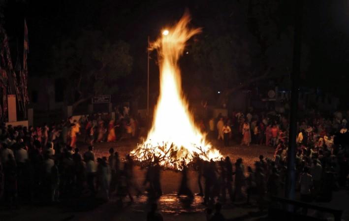 Hindu devotees walk around a bonfire during a ritual known as Holika Dahan Holika Dahan