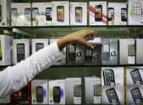 Employee takes out a Micromax mobile phone from the display at a mobile store