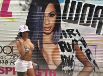 Cardi B poses in front of her poster
