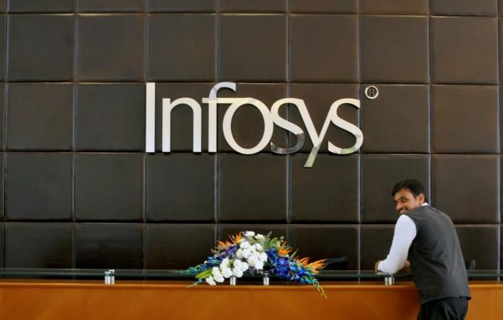 An employee of Infosys stands at the front desk of its headquarters in Bengaluru