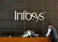 An employee of Infosys stands at the front desk of its headquarters in Bengaluru