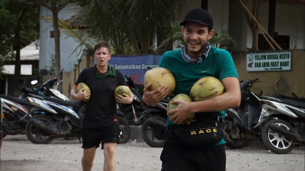 Tyler and Korey carrying coconuts during a task