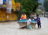Villagers pull a boat with rescued people
