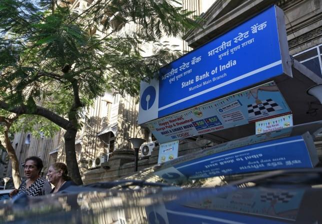People walk out of the State Bank of India main branch in Mumbai, India, March 9, 2016. sbi home loans, sbi cut interest rates on housing loans, sbi cut interest rates on deposits, sbi share price, sbi home loans lowest in industry
