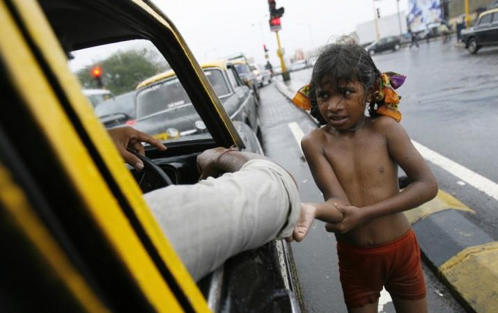 A girl begs for alms in India.