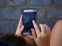 A young woman plays the augmented reality mobile game