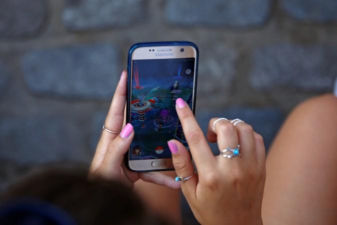 A young woman plays the augmented reality mobile game