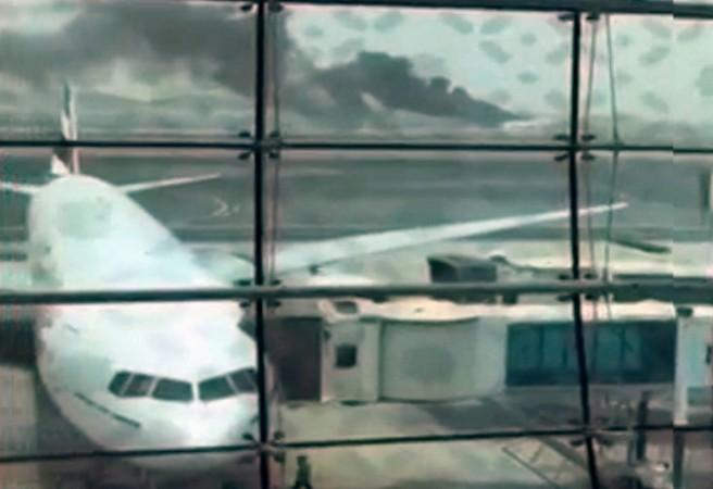 A still picture taken from an amateur video shows smoke rising (at rear) after an Emirates Airline flight crash-landed at Dubai International Airport, the UAE Aug. 3, 2016.