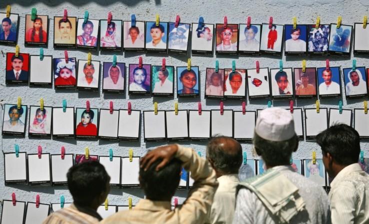 Survivors look at the pictures of the Godhra riots victims at a photo-exhibition held to commemorate its 10th anniversary in Ahmedabad, February 27, 2012. Godhra riots