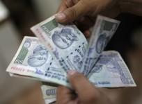 An employee counts Indian rupee currency notes inside a private money exchange office in New Delhi July 5, 2013
