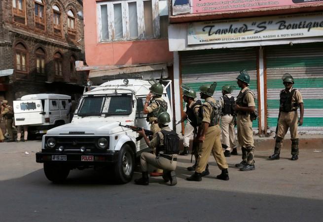 Indian policemen take position behind a jeep near the site of a gunfight between Indian Security Forces and suspected militants in Srinagar, August 15, 2016.