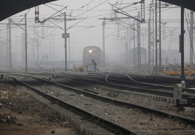 rail stocks wagons engineering texmaco kalindee titagarh rail nirman indian railways prabhu track renewal expansion infra push govt A labourer pushes a handcart past a train as he crosses railway tracks on a foggy and cold winter morning in New Delhi Janu