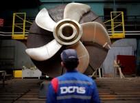 An employee looks at the propeller of a Scorpene submarine at the industrial site of the naval defence company and shipbuilder DCNS in La Montagne near Nantes, France, April 26, 2016.