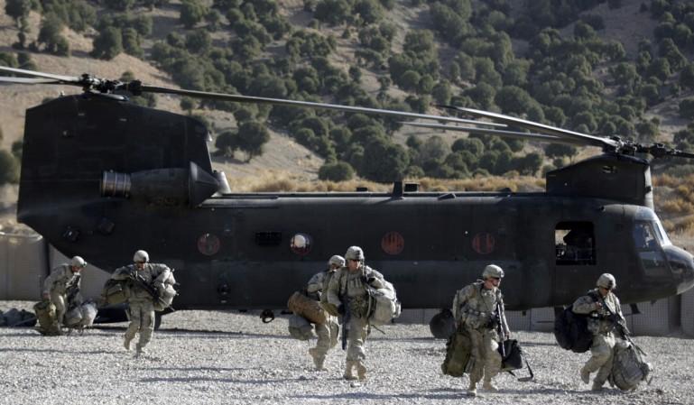 US soldiers from Task Force Geronimo walk in front of a Chinook CH-47F transport helicopter while on their way to a new location, at FOB Tillman, Afghanistan on November 15, 2009. Chinook CH-47F