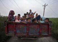 Indian villagers sit in a tractor trolley as they move to safer places at Devi Garh village near Jammu.