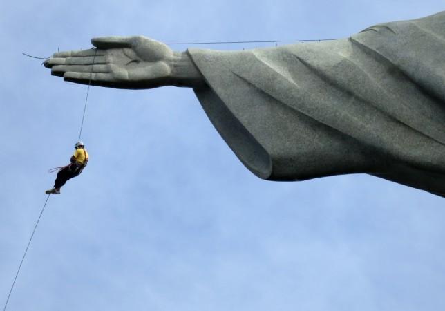 A worker rappels from the Cristo Redentor statue at the Corcovado in Rio de Janeiro, Brazil. Adventure