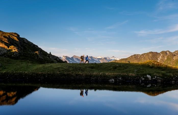 A couple hikes during sunrise on Kreuzjoch mountain in the Zillertal Alps in Schwendau, Austria. World Tourism Day 2016
