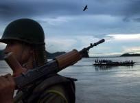 An Indian paramilitary trooper stands guard on the banks of the river Brahmaputra