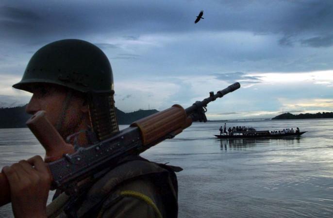 An Indian paramilitary trooper stands guard on the banks of the river Brahmaputra. An Indian paramilitary trooper stands guard on the banks of the river Brahmaputra