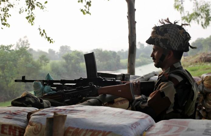 An Indian army soldier keeps guard from a bunker near the border with Pakistan in Abdullian