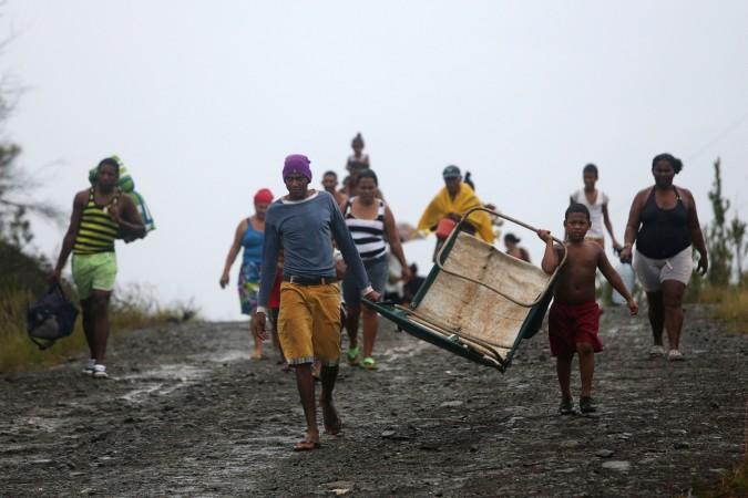 People walk back from shelters to their homes in an ox cart after the passage of Hurricane Matthew.
