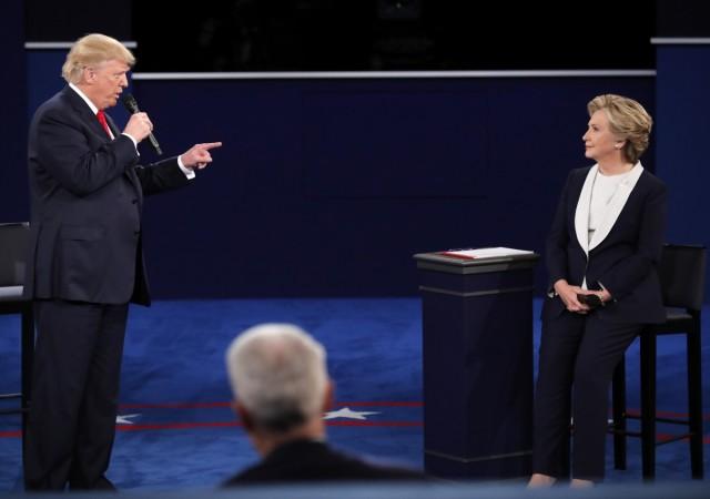 Republican U.S. presidential nominee Donald Trump speaks as Democratic U.S. presidential nominee Hillary Clinton listens during their presidential town hall debate at Washington University in St. Louis, Missouri, U.S., October 9, 2016. Donald Trump and Hillary Clinton