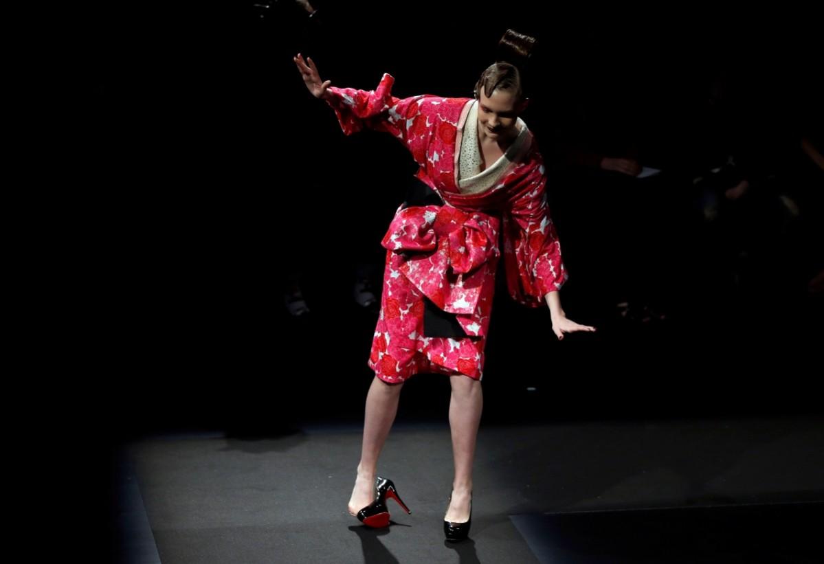 A model struggles with a shoe as she presents a creation by designer Yoshiki, leader of Japan's band Tokyo Fashion Week