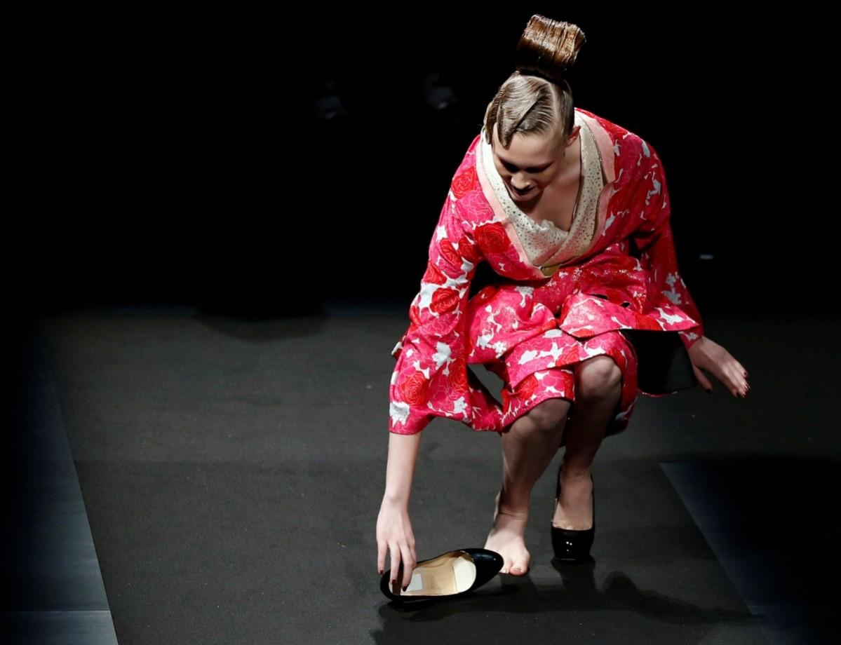 A model struggles with a shoe as she presents a creation by designer Yoshiki, leader of Japan's band Tokyo Fashion Week