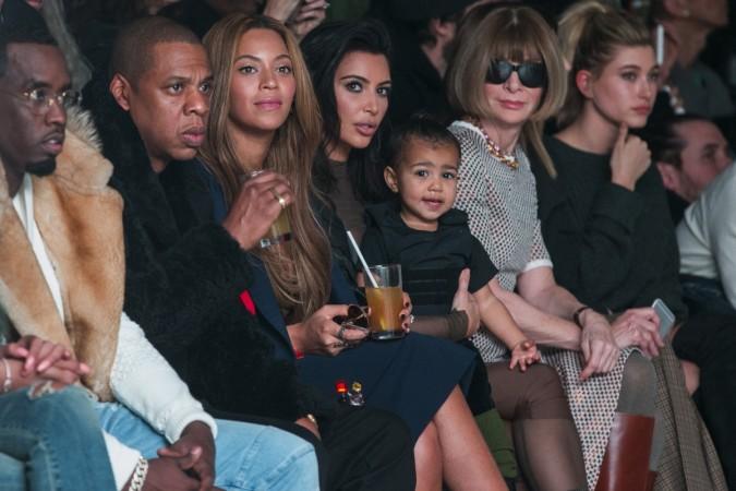 Kim Kardashian holds her daughter, North, while sitting next to Sean Combs (L), Jay-Z (2nd L), Beyonce (3rd L) and Anna Wintour (3rd R) as they watch a presentation of Kanye West's Fall/Winter 2015 partnership with Adidas at New York Fashion Week February 12, 2015. Beyonce and Kim Kardashian