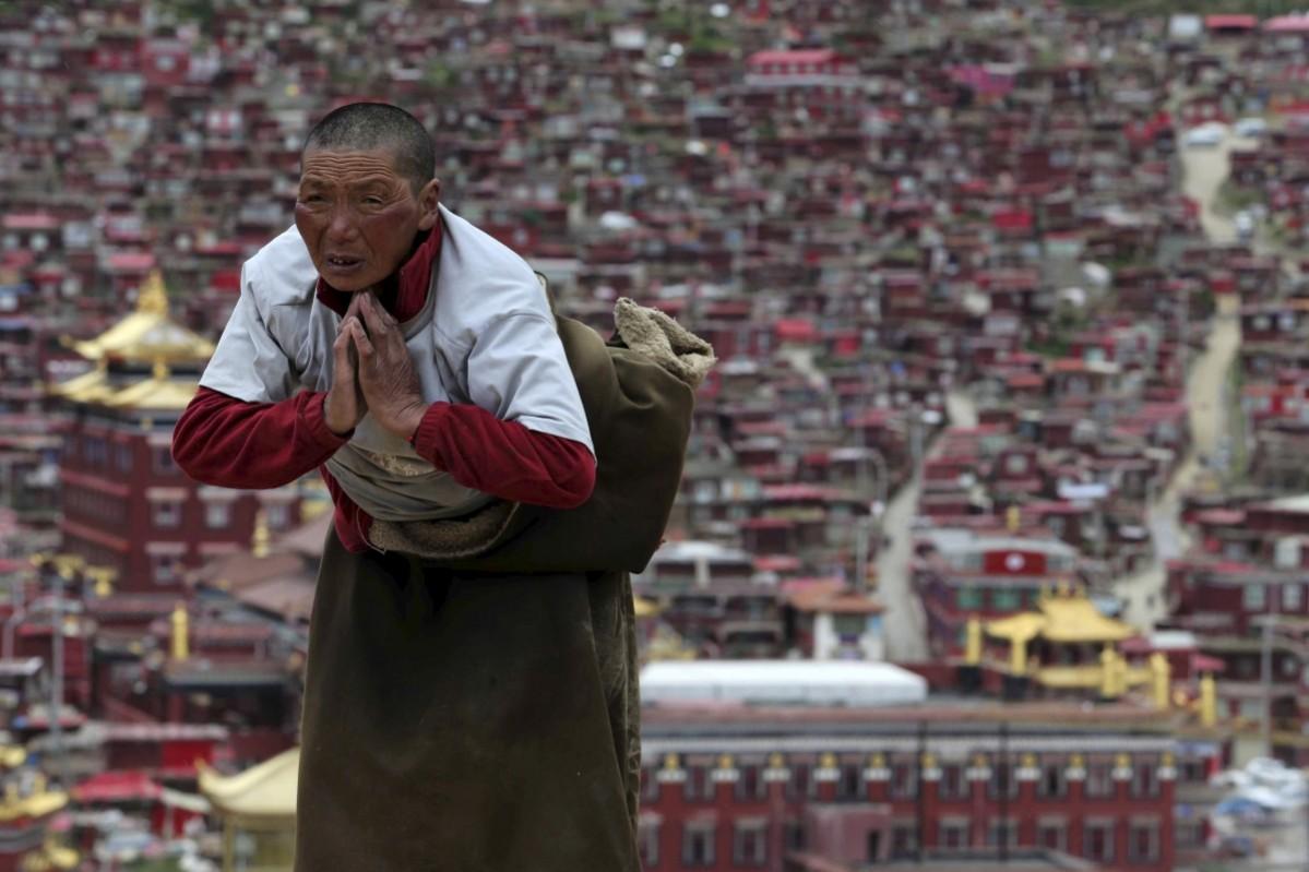 A Tibetan pilgrim prays near a Buddhist temple in Sertar County of Garze Tibetan Autonomous Prefecture, Sichuan province, China, July 20, 2015. Larung Gar Buddhist Academy