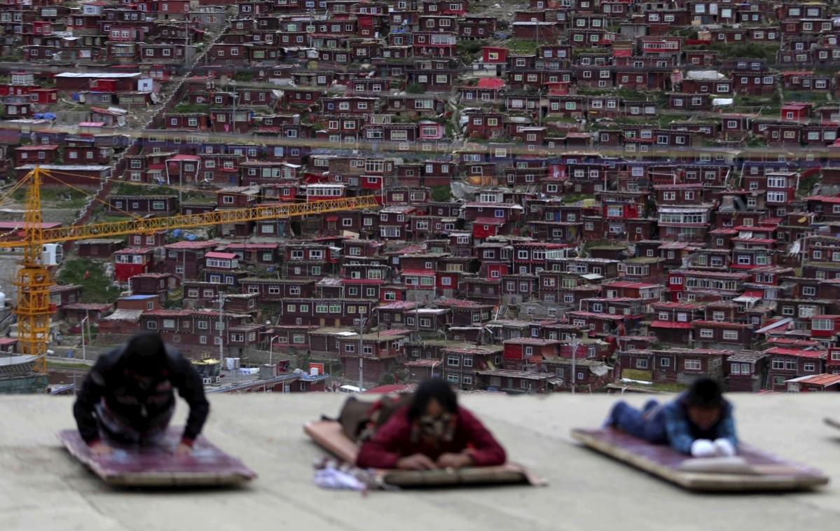 Pilgrims lie on the floor as they pray near a Buddhist temple in Sertar County of Garze Tibetan Autonomous Prefecture, Sichuan province, China, July 20, 2015. Larung Gar Buddhist Academy