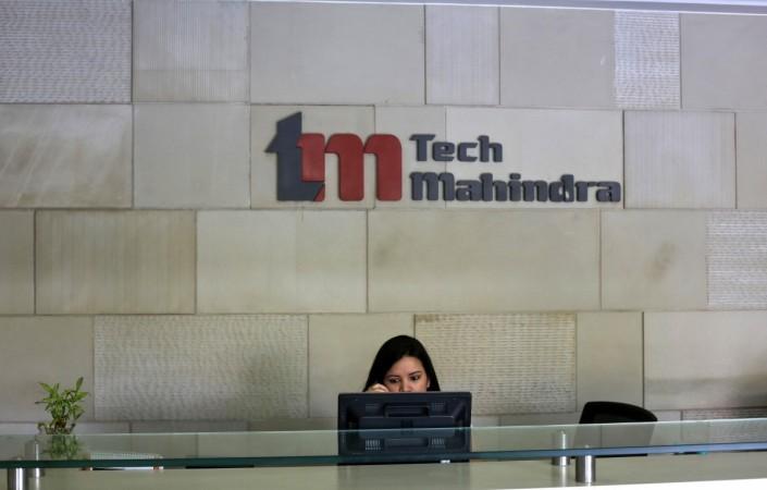 An employee sits at the front desk inside Tech Mahindra office building in Noida on the outskirts of New Delhi March 18, 2013. tech mahindra q2 results net profit share price revenues income operations margins nasscom growth it industry body projections estimate gurnani