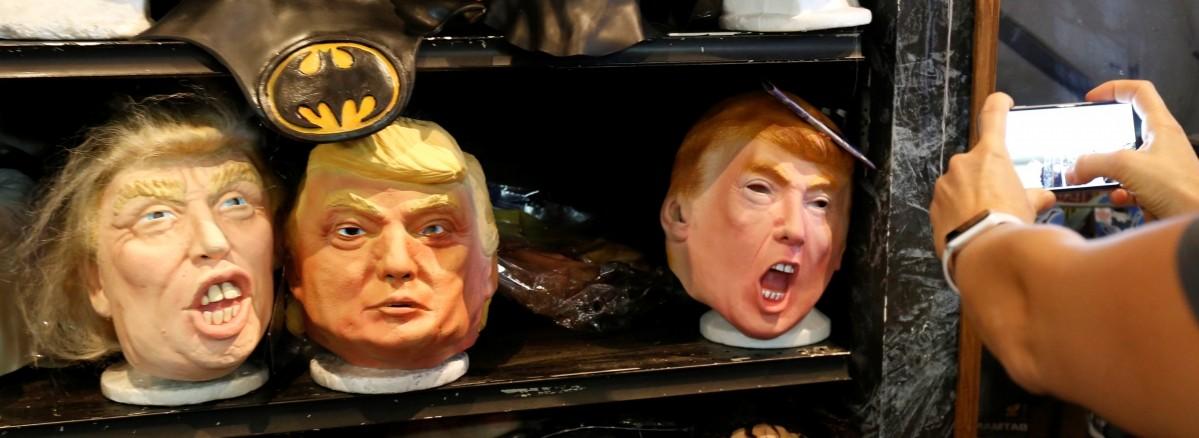 A person takes a photo of masks depicting Republican presidential nominee Donald Trump at Hollywood Toys & Costumes in Los Angeles, California U.S., halloween