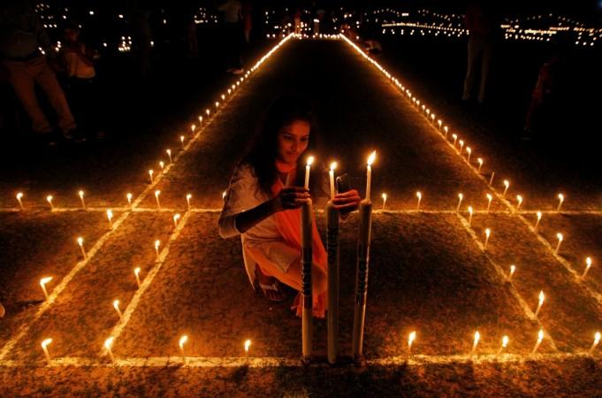 A girl lights candles inside a cricket stadium on the eve of Diwali, the Hindu festival of lights, in Allahabad, India. Diwali 2022