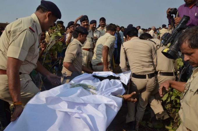 Policemen take away body of one of the eight terrorists of the banned Students Islamic Movement of India (SIMI) who escaped from Bhopal Central Jail and were killed in a gunfight with police on the outskirts of the city on Oct 31, 2016. simi encounter bjp congress madhya pradesh gujarat comparison human rights violation nationalism anti-national farce tweets criticism amit shah