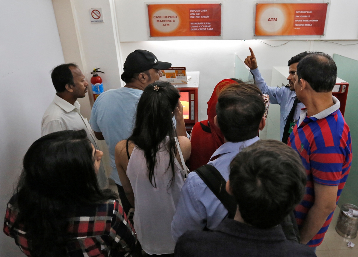 A security guard speaks to customers after a cash deposit machine stopped working at a bank in Mumbai, India, November 8, 2016. ban on currency rs 500 1,000 1000 note modi rbi demonetization black money scrapped new notes 2000 new 500 coins legal tender rbi sit narendra