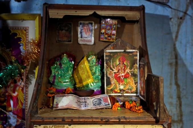 1000 Indian rupee banknotes are seen kept in front of idols and pictures of Hindu deities at a shop on the outskirts of northern city of Kanpur, India November 9, 2016. India rupee