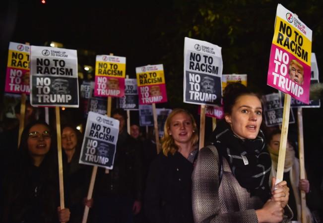 People hold placards at an anti-racism protest against U.S. President-elect Donald Trump outside of the U.S. Embassy in London, Britain, November 9, 2016. Anti-Trump protest