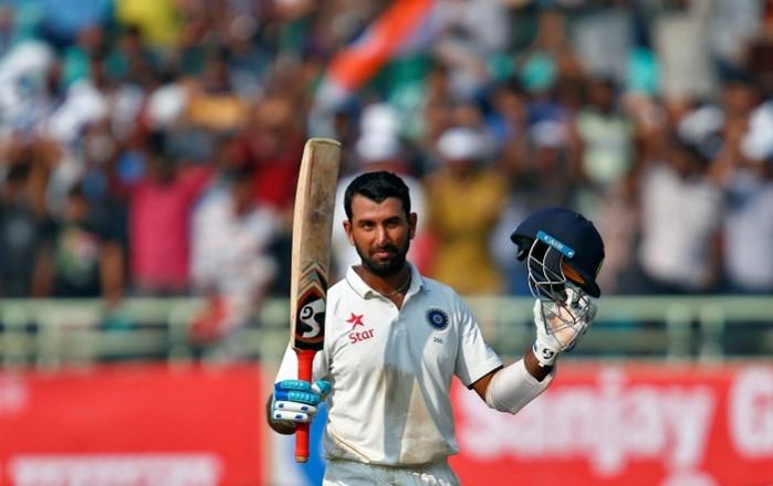 Cheteshwar Pujara raises his bat after completing his third hundred in three Test matches, November 17, 2016 Cheteshwar Pujara India England